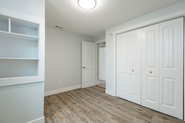 unfurnished bedroom featuring light hardwood / wood-style floors and a closet