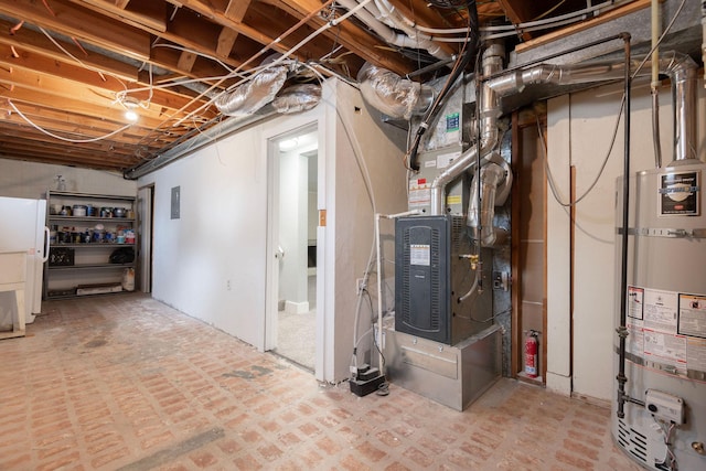 basement with heating unit, strapped water heater, electric panel, and white fridge