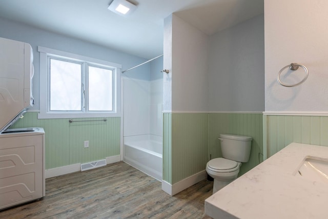 full bathroom featuring wood-type flooring, toilet,  shower combination, and vanity