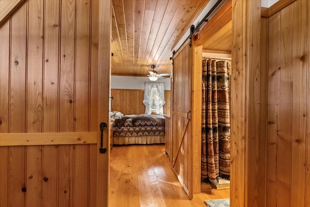 192 Crystal Lakes Dr, Eureka, MT 59917 - hallway featuring wood walls, wood ceiling, light wood finished floors, and a barn door