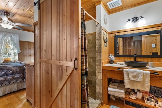 192 Crystal Lakes Dr, Eureka, MT 59917 - ensuite bathroom with wood ceiling, tiled shower, wood walls, wood finished floors, and vanity