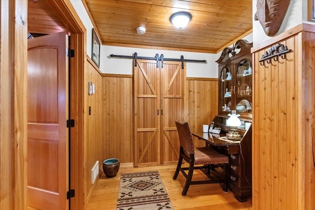 192 Crystal Lakes Dr, Eureka, MT 59917 - home office featuring wooden walls, wainscoting, light wood finished floors, wooden ceiling, and a barn door