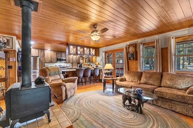 192 Crystal Lakes Dr, Eureka, MT 59917 - living area with a wood stove, wood ceiling, ceiling fan, and light wood-style floors