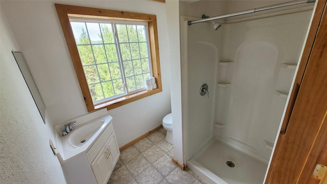 bathroom featuring a shower, vanity, and toilet