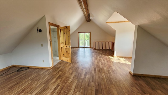 additional living space featuring vaulted ceiling with beams and dark hardwood / wood-style floors