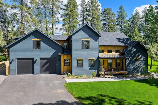 modern inspired farmhouse with a garage, a front lawn, and covered porch