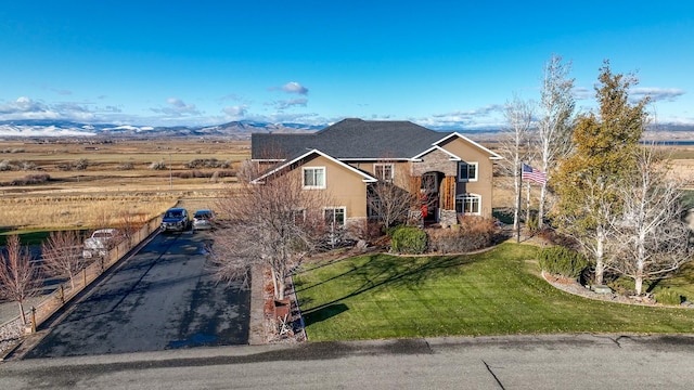 view of front of house featuring a mountain view and a front lawn