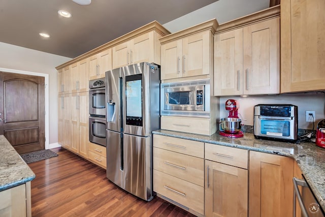 kitchen with dark wood-type flooring, stainless steel appliances, light stone countertops, and light brown cabinets