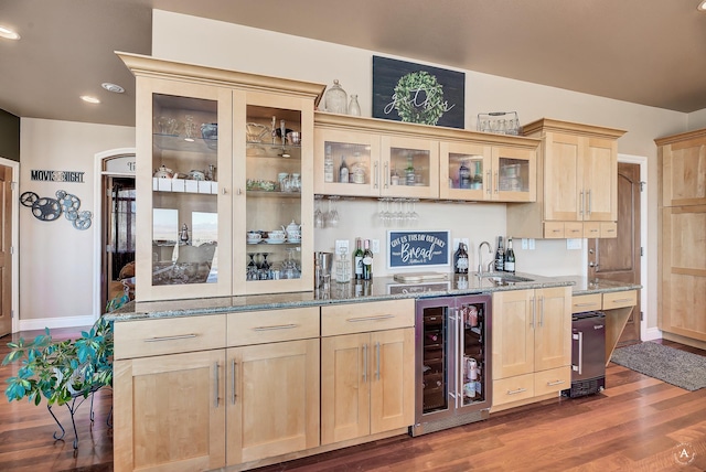 kitchen featuring sink, dark stone countertops, and beverage cooler