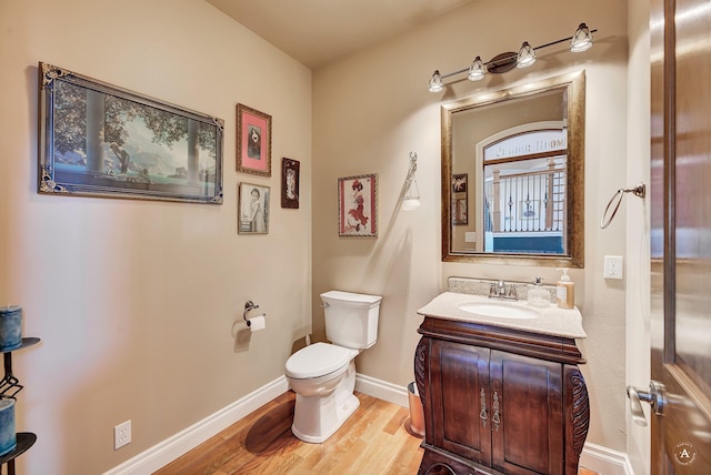 bathroom featuring vanity, hardwood / wood-style flooring, and toilet