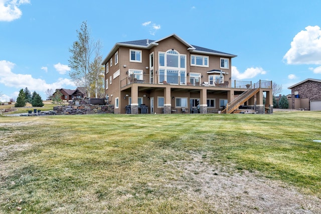 rear view of property with a wooden deck, a balcony, and a yard