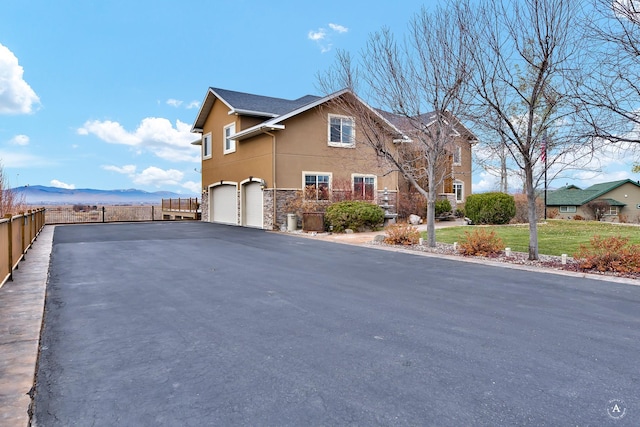 view of side of home featuring a garage and a mountain view