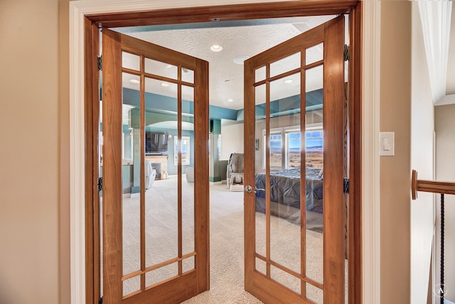 doorway featuring french doors, carpet floors, and a textured ceiling