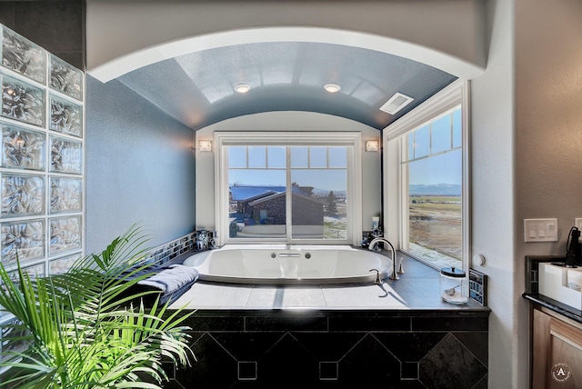 4428 Fox View Loop, Helena, MT 59602 - full bathroom featuring a bath, plenty of natural light, a textured wall, and lofted ceiling