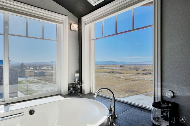 bathroom featuring lofted ceiling and a mountain view