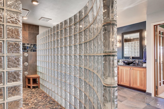 4428 Fox View Loop, Helena, MT 59602 - bathroom featuring a walk in shower, vanity, tile walls, and a textured ceiling