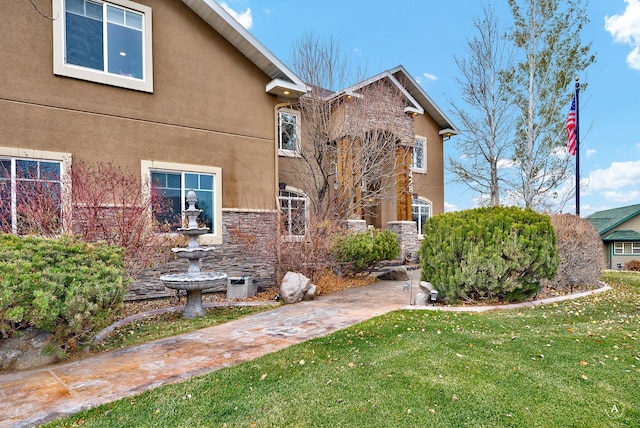 4428 Fox View Loop, Helena, MT 59602 - view of front of property with stone siding, a front lawn, and stucco siding