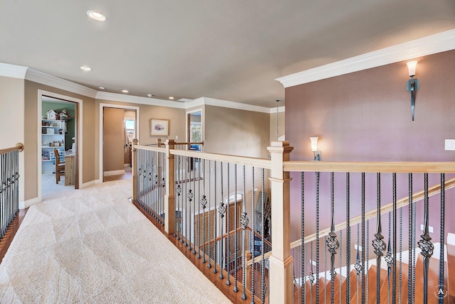 hall with ornamental molding and light colored carpet