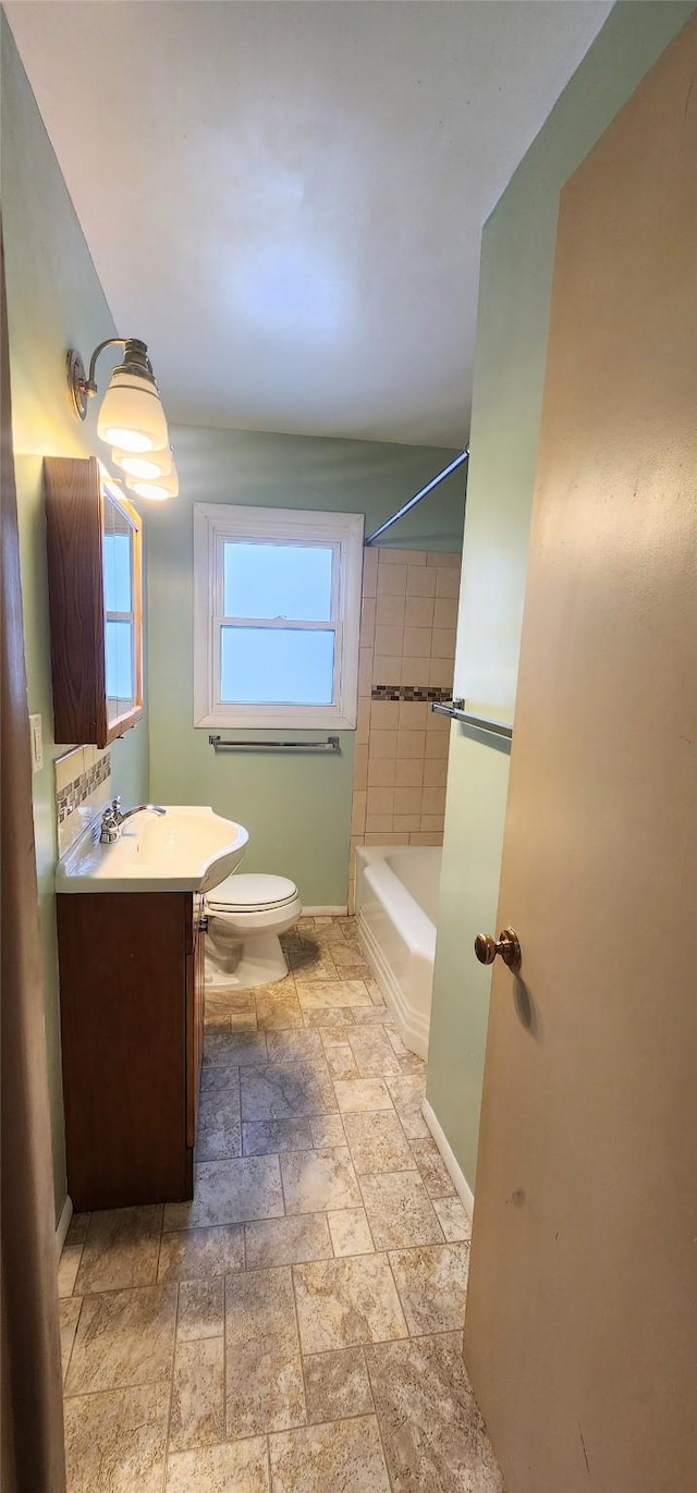 full bathroom with tiled shower / bath combo, vanity, and toilet