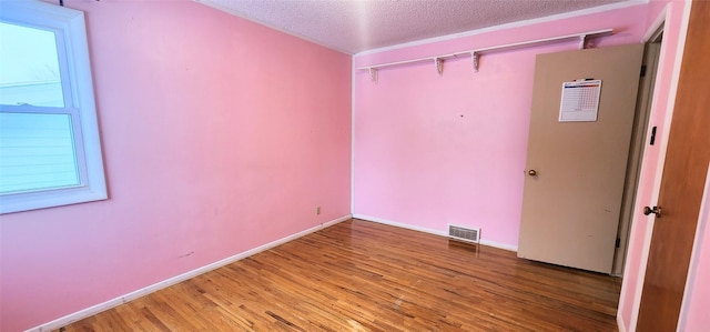 unfurnished room featuring hardwood / wood-style floors and a textured ceiling