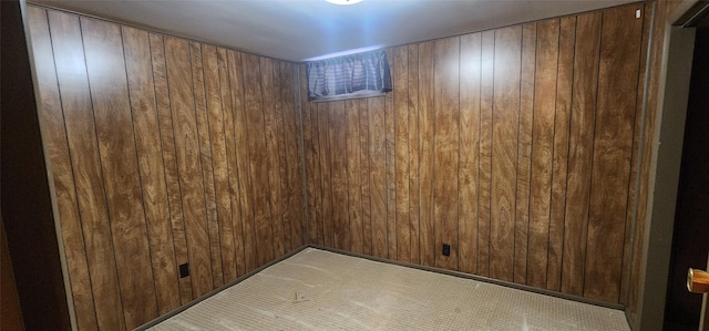 unfurnished room featuring wood walls