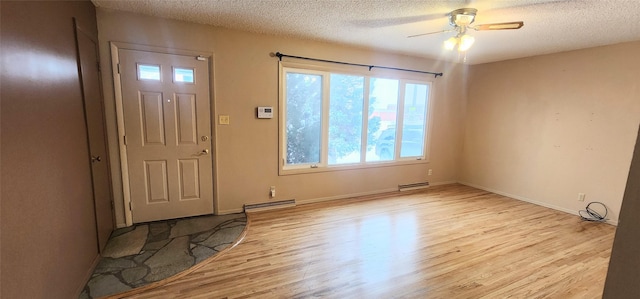 entryway with ceiling fan, light hardwood / wood-style flooring, and a textured ceiling