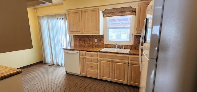 kitchen with white appliances, light brown cabinetry, sink, and backsplash