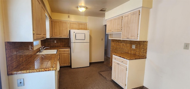 kitchen featuring white fridge, sink, and decorative backsplash