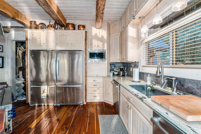 kitchen featuring appliances with stainless steel finishes, dark hardwood / wood-style floors, sink, backsplash, and hanging light fixtures