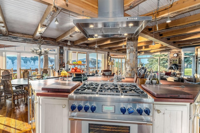 kitchen with island range hood, stainless steel stove, wood ceiling, a mountain view, and beam ceiling