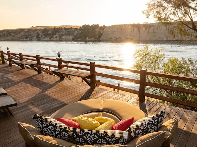 view of dock with a deck with water view and an outdoor living space with a fire pit