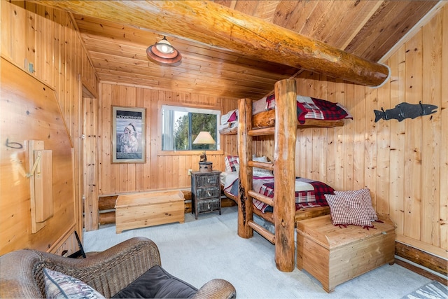 carpeted bedroom with wooden ceiling and wood walls