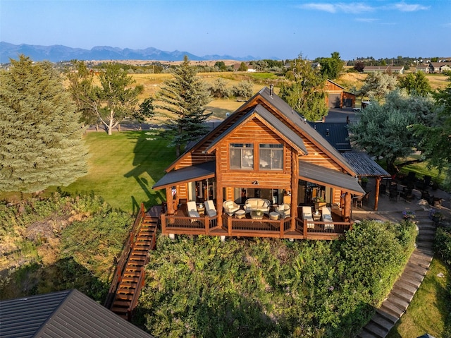 back of property featuring an outdoor living space, a yard, and a deck with mountain view