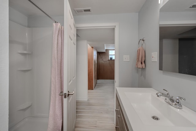 bathroom with vanity, hardwood / wood-style floors, and walk in shower