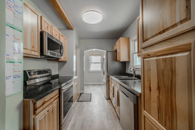 kitchen featuring stainless steel appliances, sink, light brown cabinetry, and light hardwood / wood-style floors