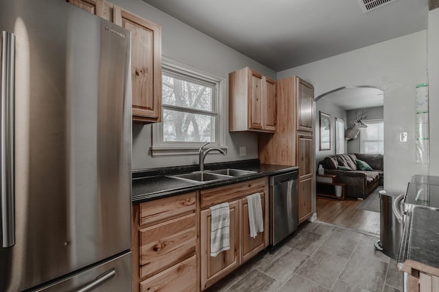 kitchen with appliances with stainless steel finishes, sink, light brown cabinets, and plenty of natural light