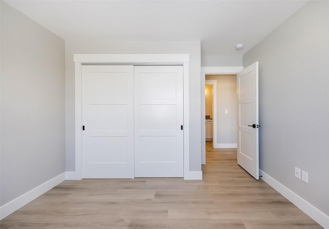 unfurnished bedroom with a closet and light hardwood / wood-style flooring