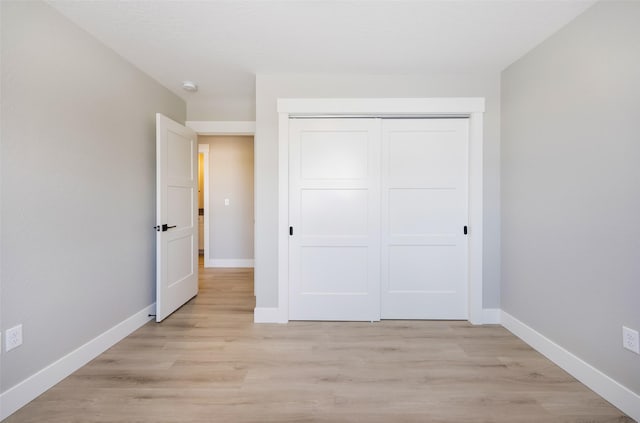 unfurnished bedroom with a closet and light hardwood / wood-style flooring