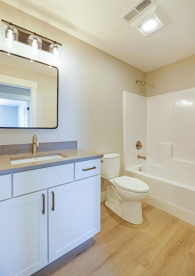 full bathroom featuring hardwood / wood-style flooring, vanity, bathtub / shower combination, and toilet