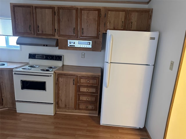 kitchen featuring white appliances, extractor fan, and light hardwood / wood-style flooring