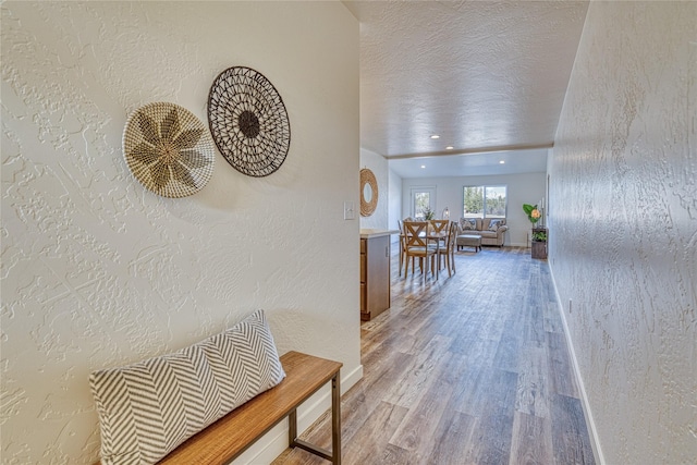 corridor with hardwood / wood-style flooring and a textured ceiling