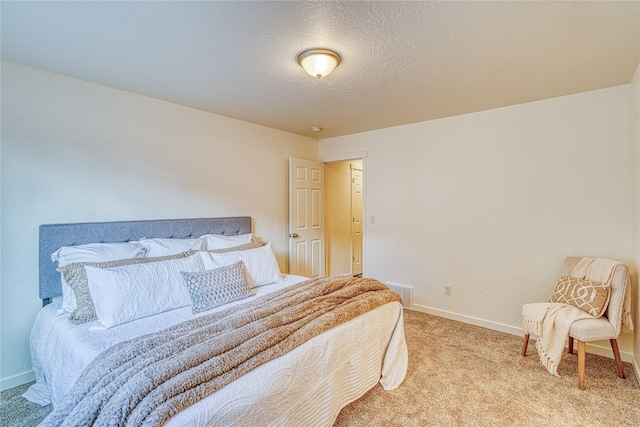 bedroom featuring light colored carpet and a textured ceiling