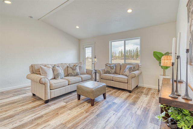 living room featuring vaulted ceiling and light hardwood / wood-style floors