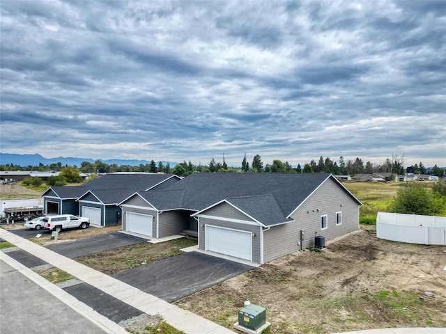 view of front of property featuring a garage, a mountain view, and central air condition unit