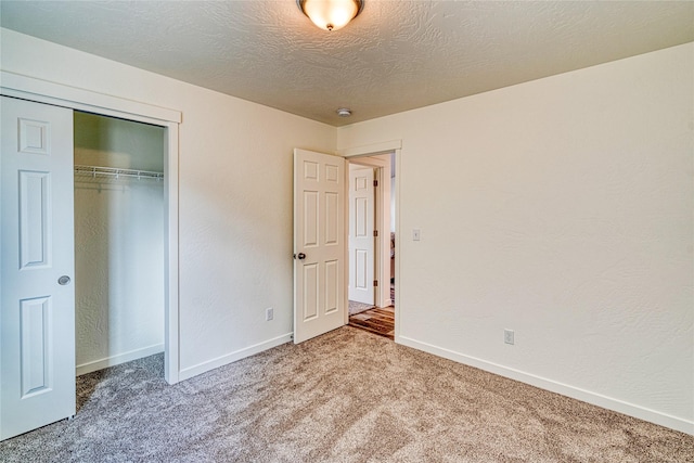 unfurnished bedroom with a closet, a textured ceiling, and carpet flooring