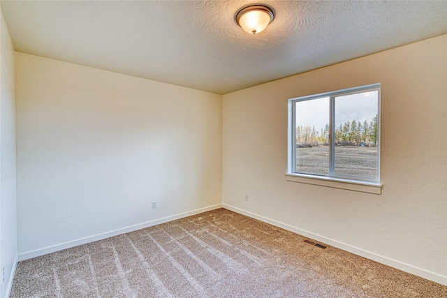 unfurnished room featuring carpet flooring and a textured ceiling