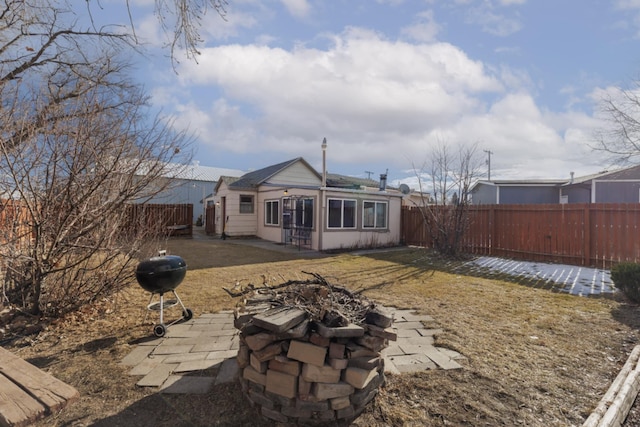 back of property with a patio area and a fire pit