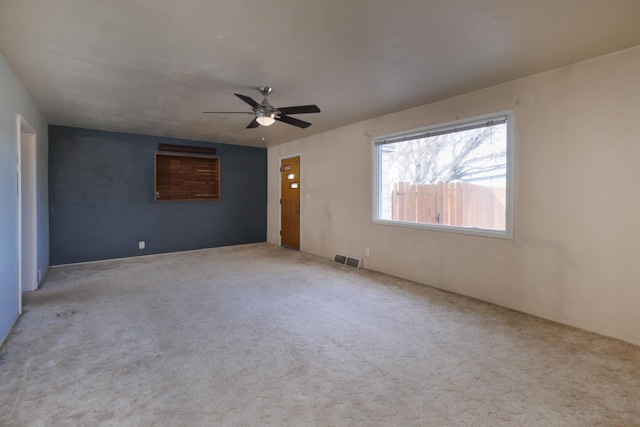 empty room featuring ceiling fan and light colored carpet