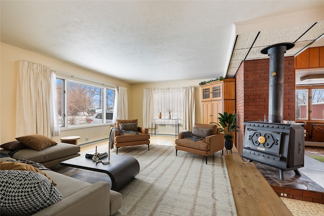 living room featuring hardwood / wood-style flooring, a textured ceiling, a healthy amount of sunlight, and a wood stove