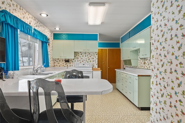 119 Fair St, Deer Lodge, MT 59722 - kitchen featuring wallpapered walls, white electric stove, light countertops, a sink, and a peninsula